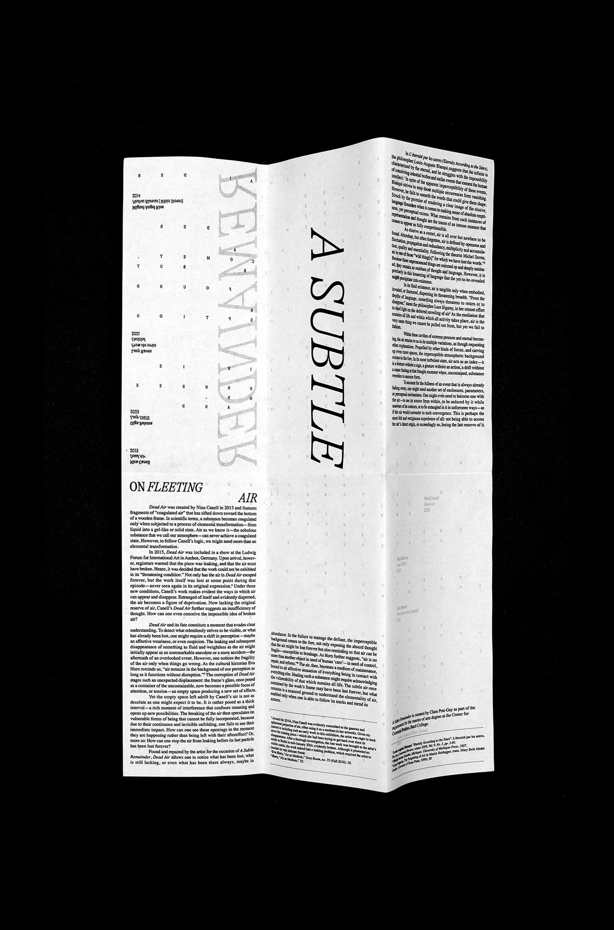 Fully unfolded A Subtle Remainder exhibition text sheet on a black background