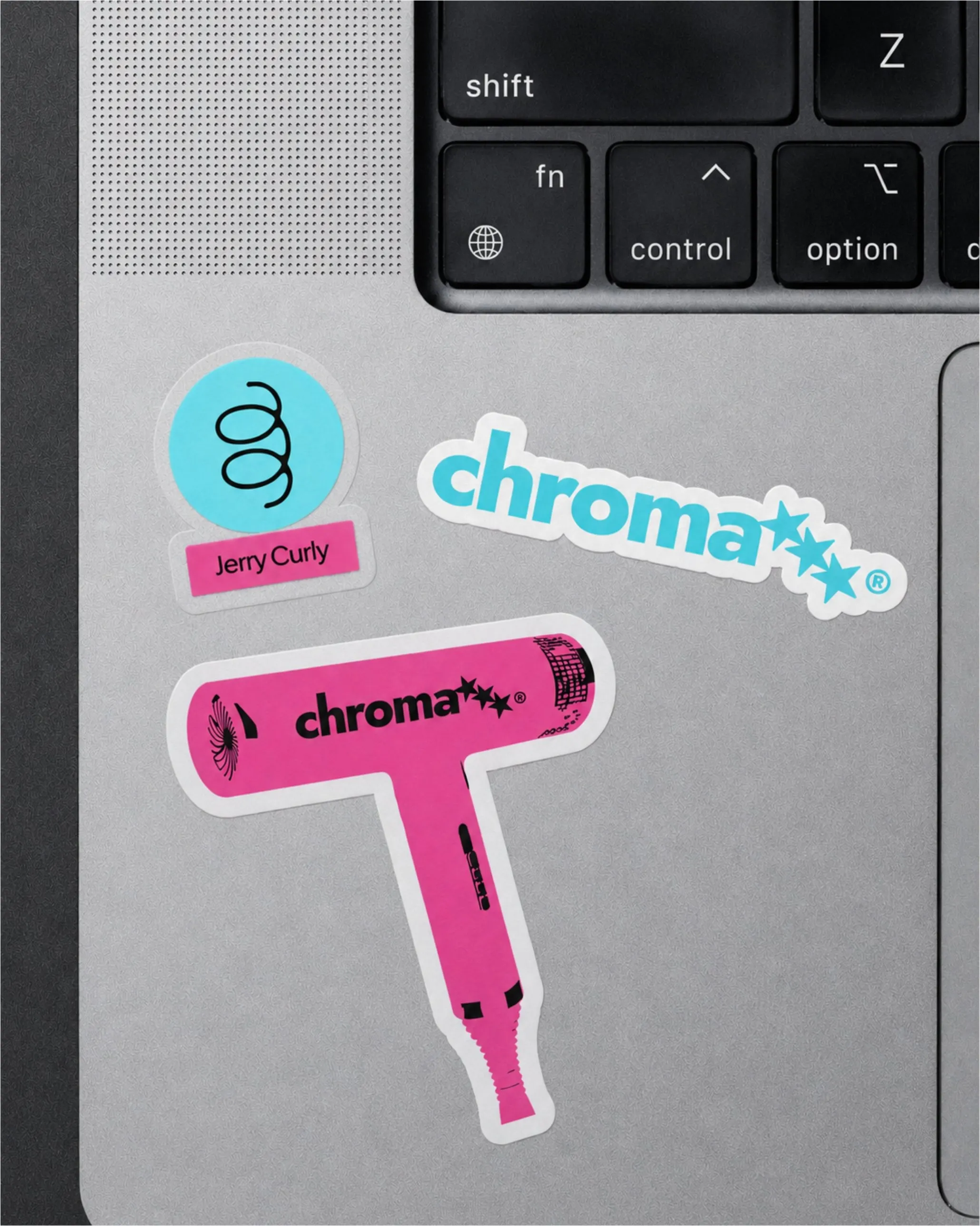 Chroma stickers on a laptop: a pink hair dryer, the aqua wordmark and a Jerry Curly label