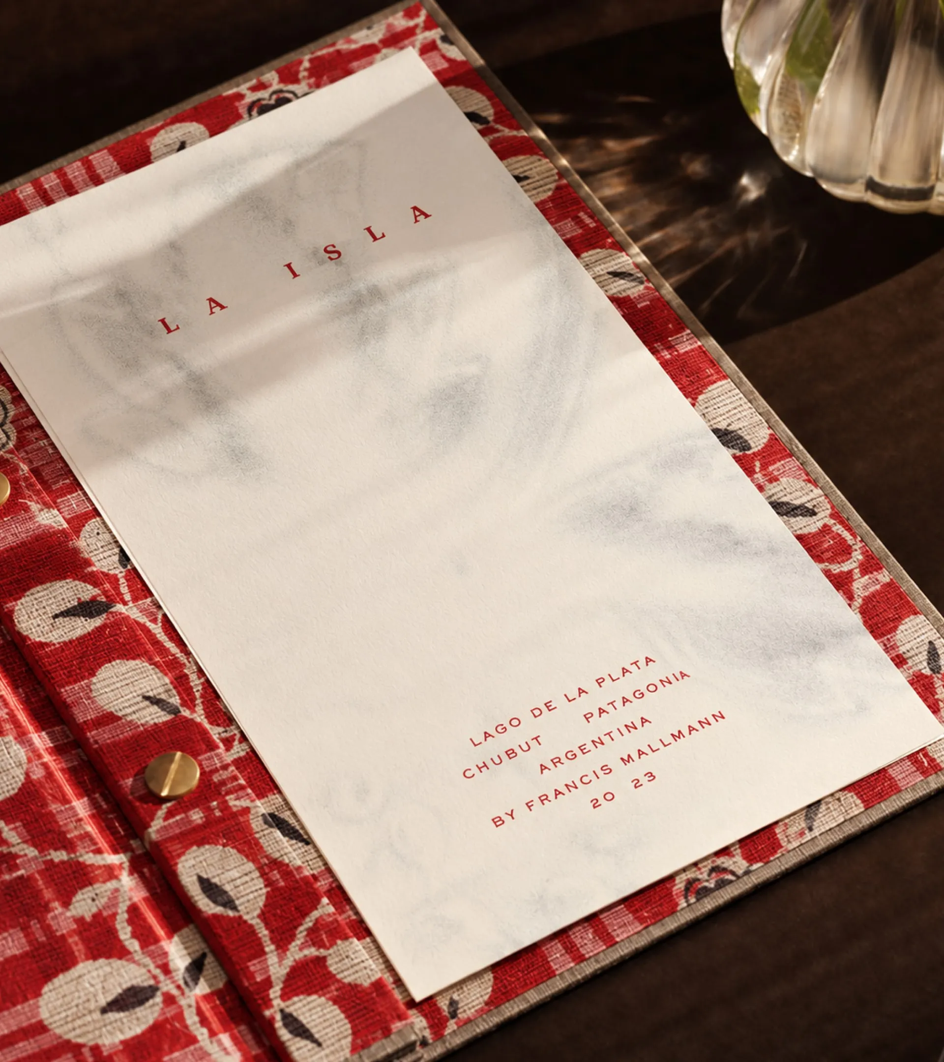 La Isla menu cover in red lettering on a red floral textile folder