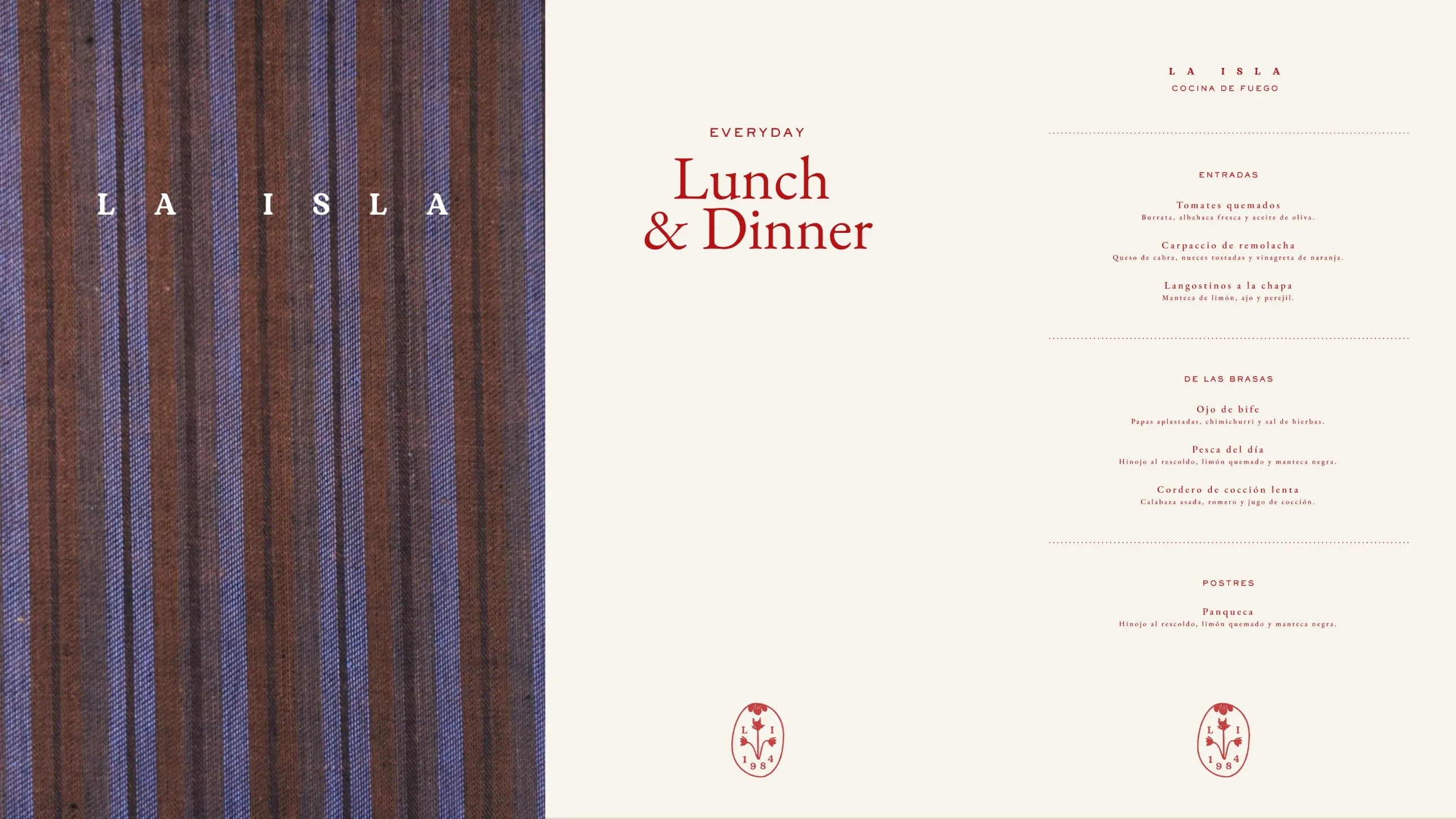 La Isla lunch and dinner menu in red beside a striped textile cover