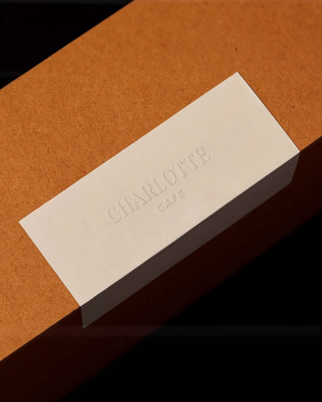 Embossed Charlotte Cafe label on a kraft paper box
