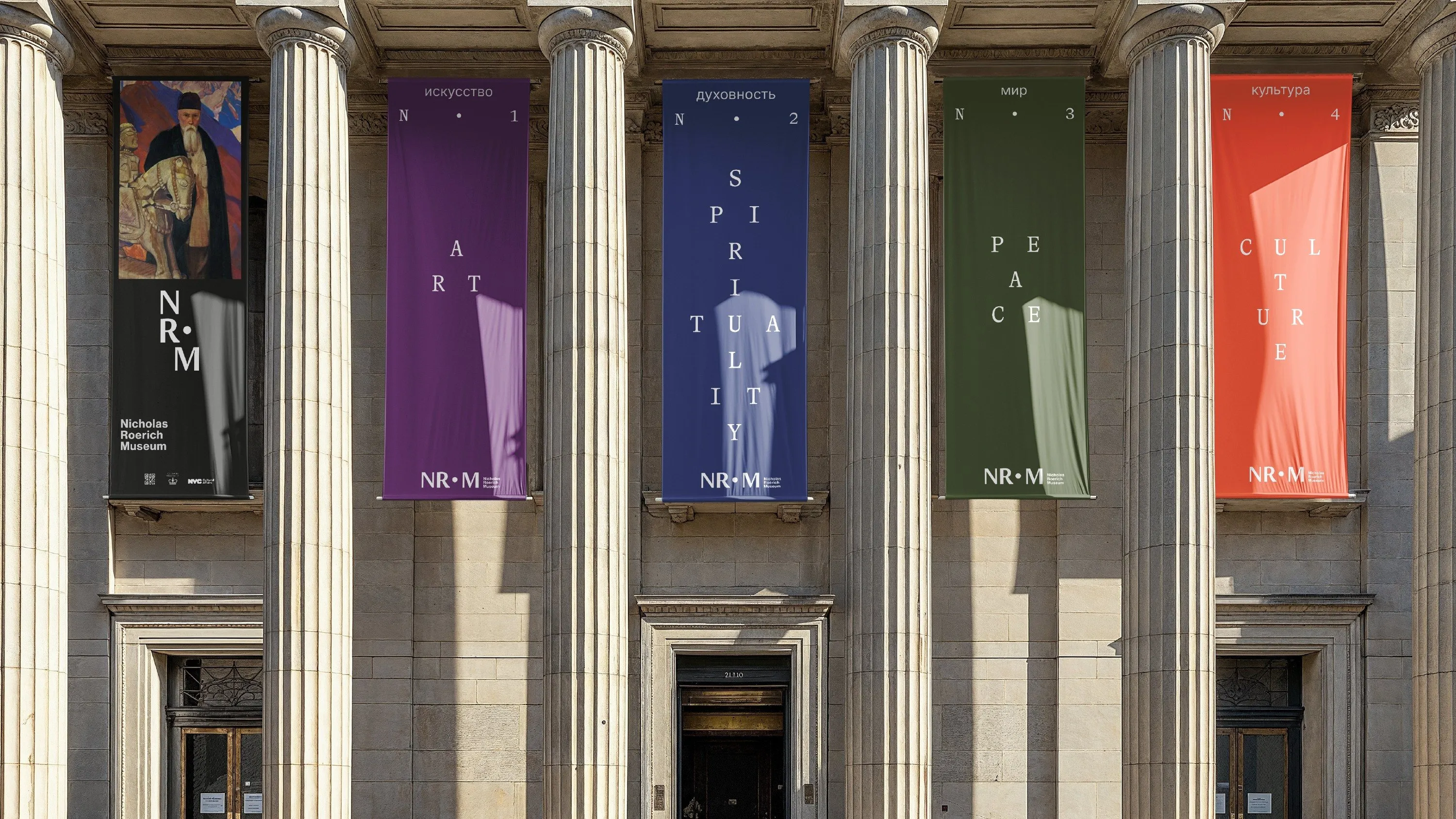 Tall banners for art, spirituality, peace and culture hung between the columns of a museum facade
