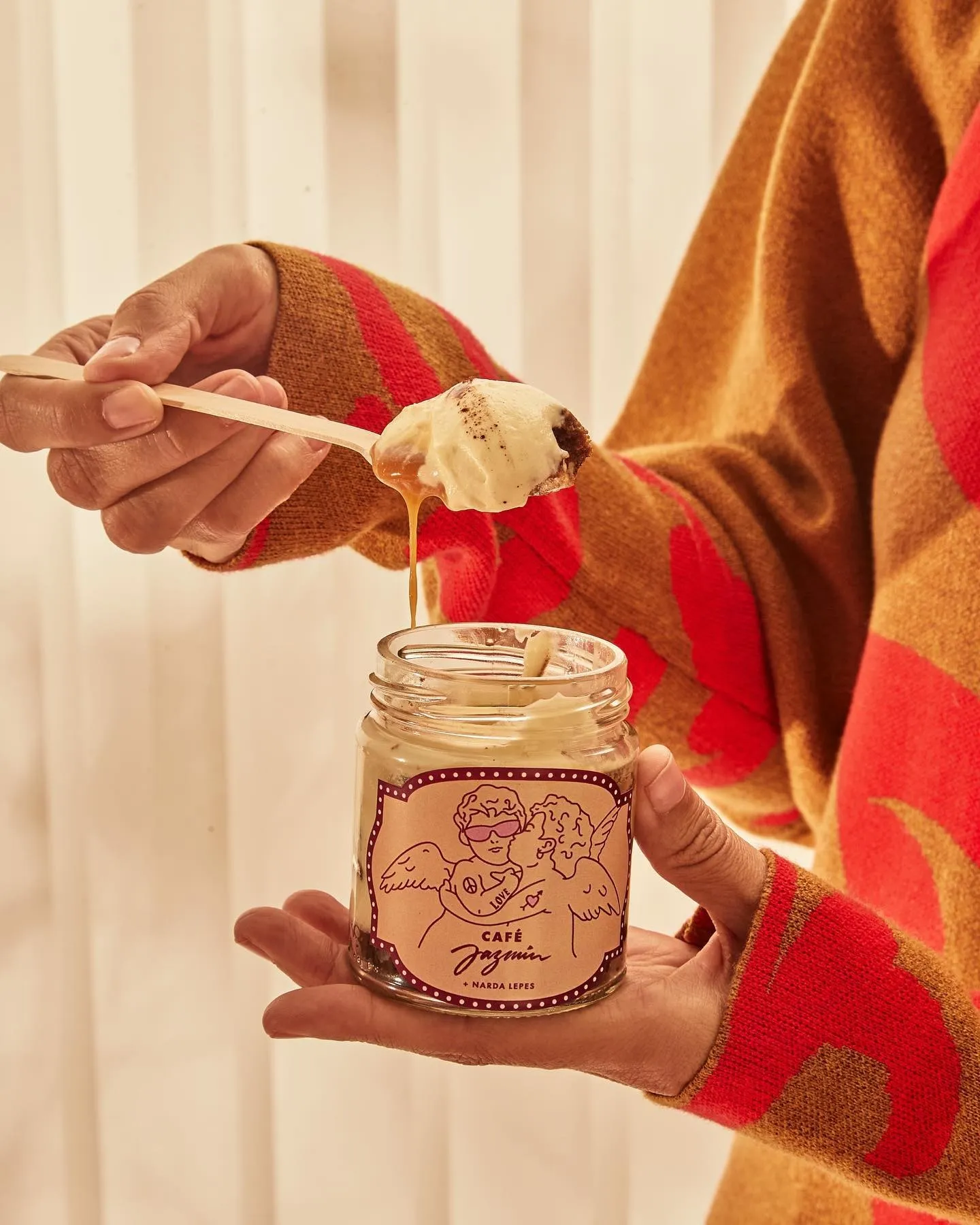 Spoon lifting dessert from a Café Jazmín jar with angel label