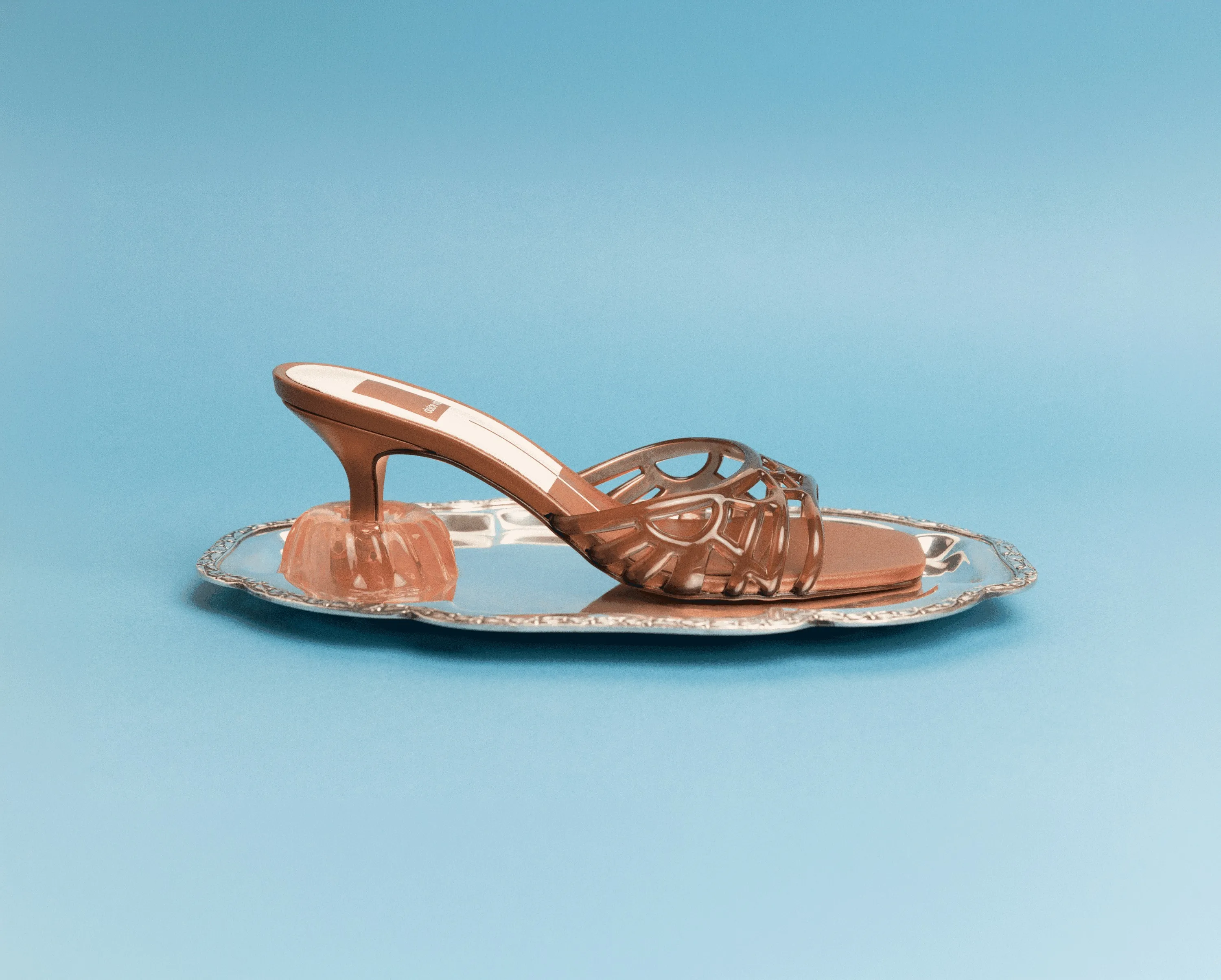 Dolce Vita bronze cutout heel on a silver tray against pale blue