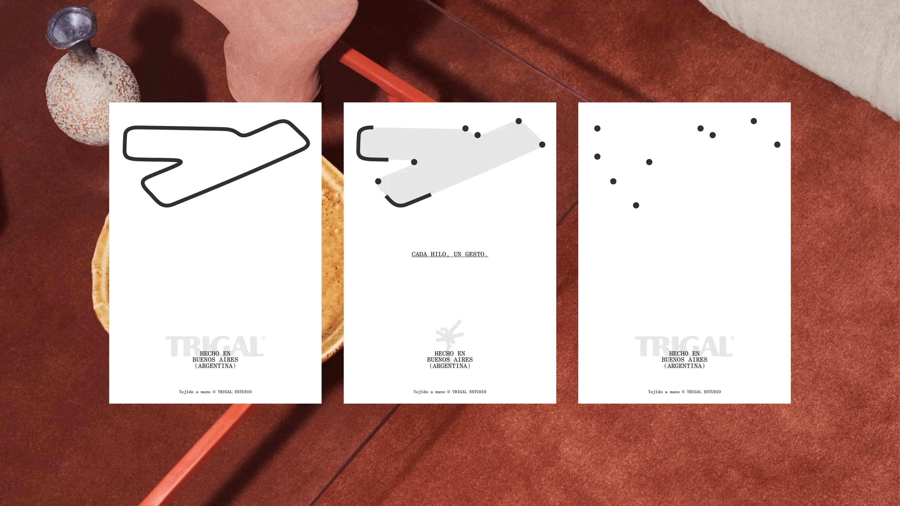 Three Trigal cards with the stem drawn as a line, a shape and dots, on a terracotta rug
